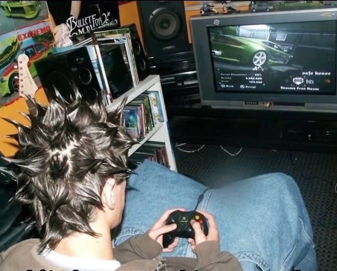 Kid with spiky hair playing Xbox in a room full of posters and CDs